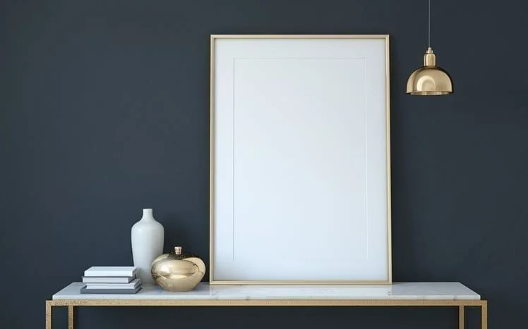 Goldener Bilderrahmen auf Sideboard