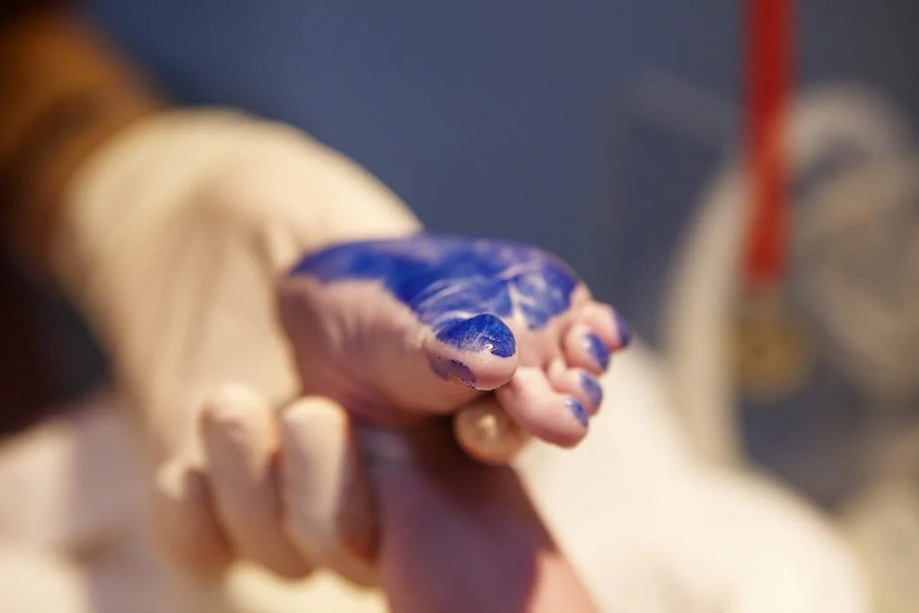 Babyfuß mit blauer Farbe