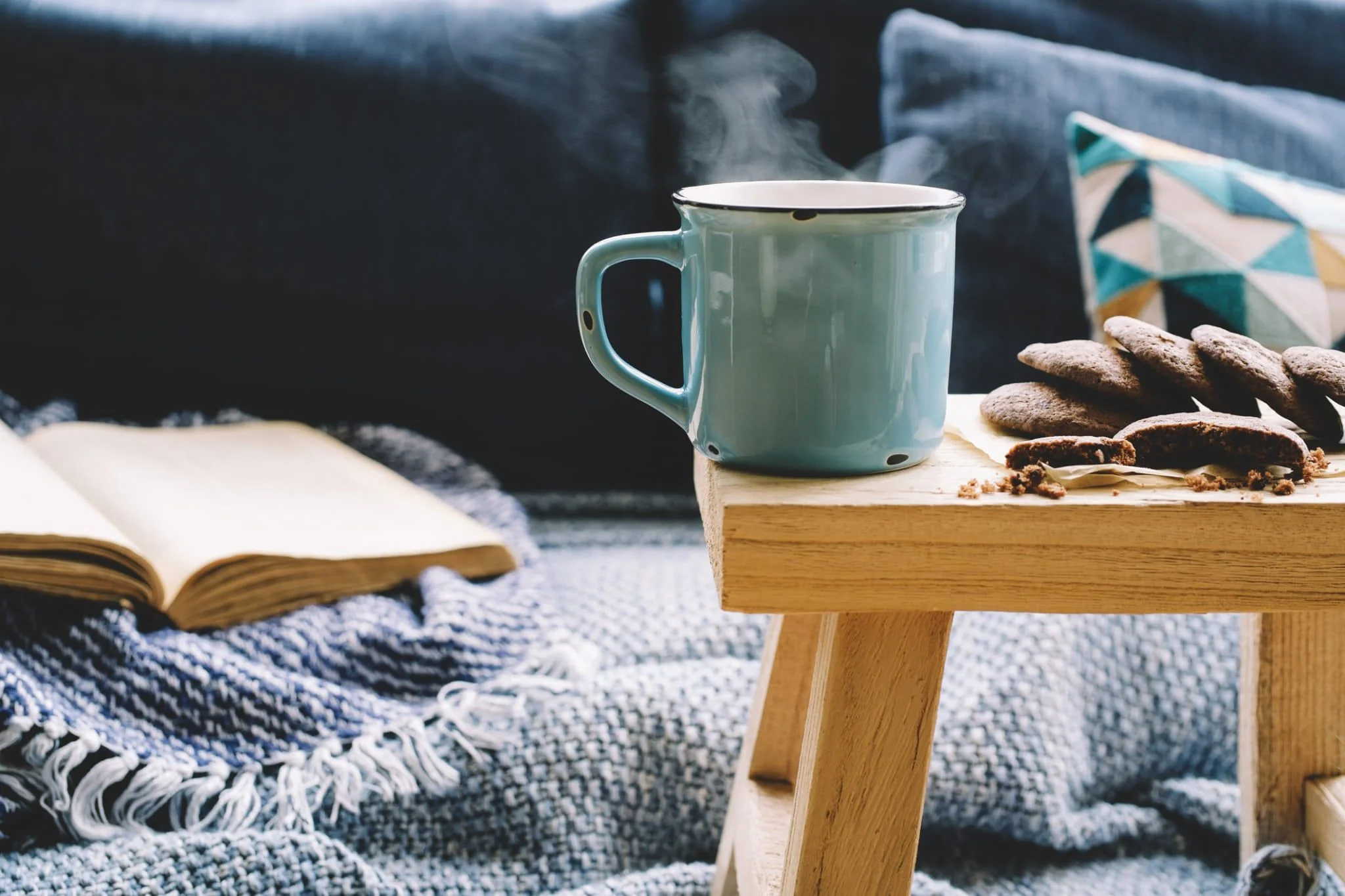 Hygge-Sofa mit Decke und Tasse.