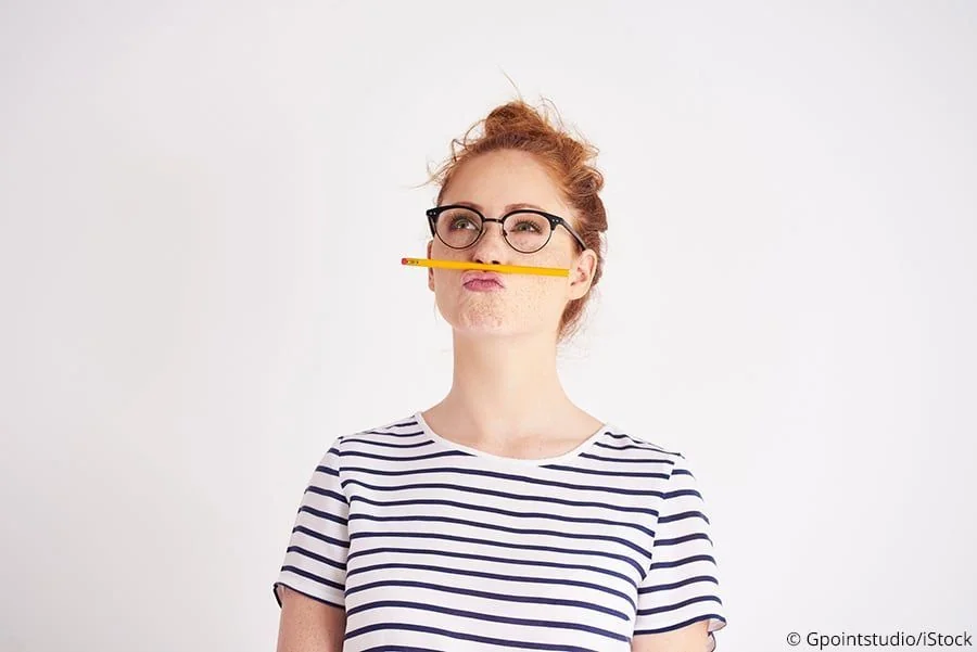 Frau mit Bleistift, um Fotos vor dem Lagern zu beschriften.