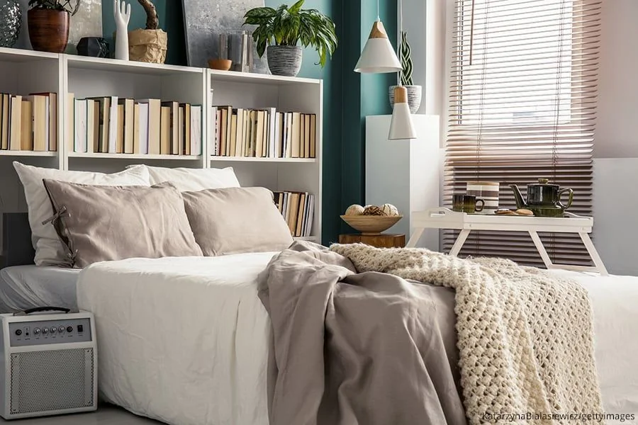 Bücherregal als Wandgestaltung hinterm Bett.
