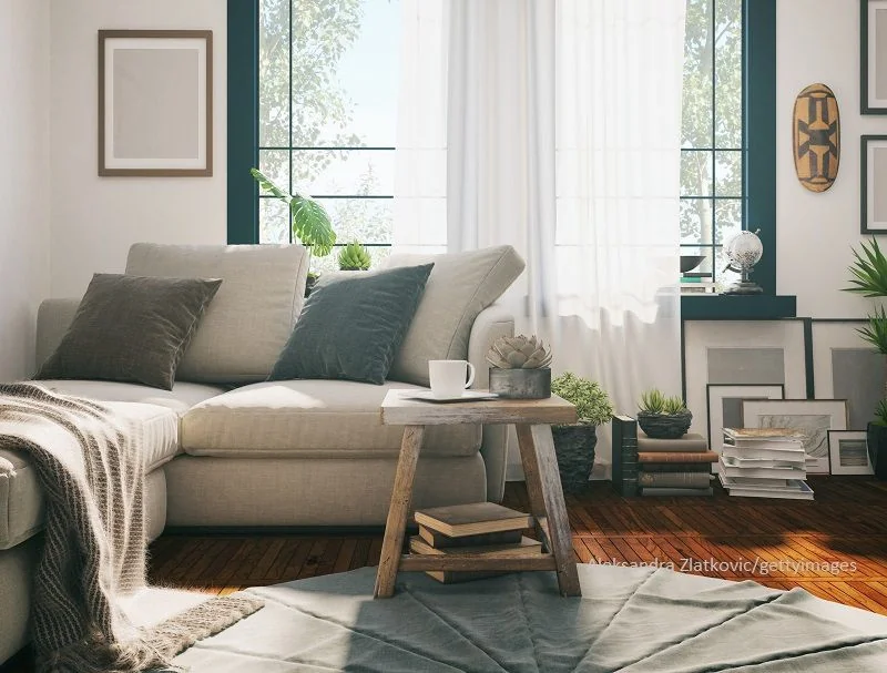 wohnzimmer mit Sofa und dekorativen Bildern am Boden