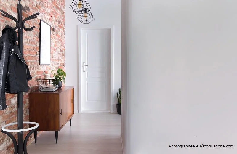 Stylischer Flur mit Garderobe und Ziegelwand