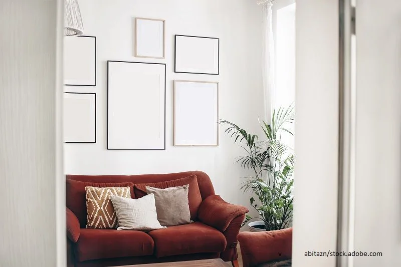 Bilderwand mit leeren Bilderrahmen im Wohnzimmer