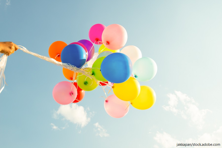 Hand, die mehrfarbige Luftballons hält