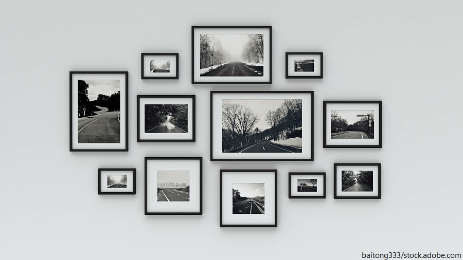 Eingerahmte Reisefotos in verschiedenen Rahmen hängen an einer Wand